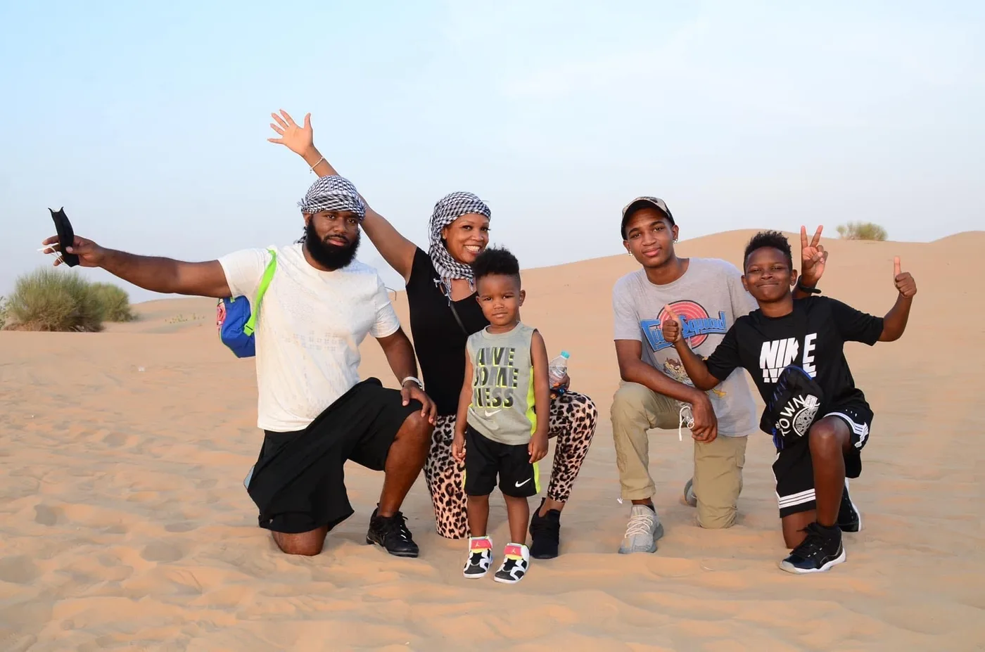 Family together on a sunlit desert dune