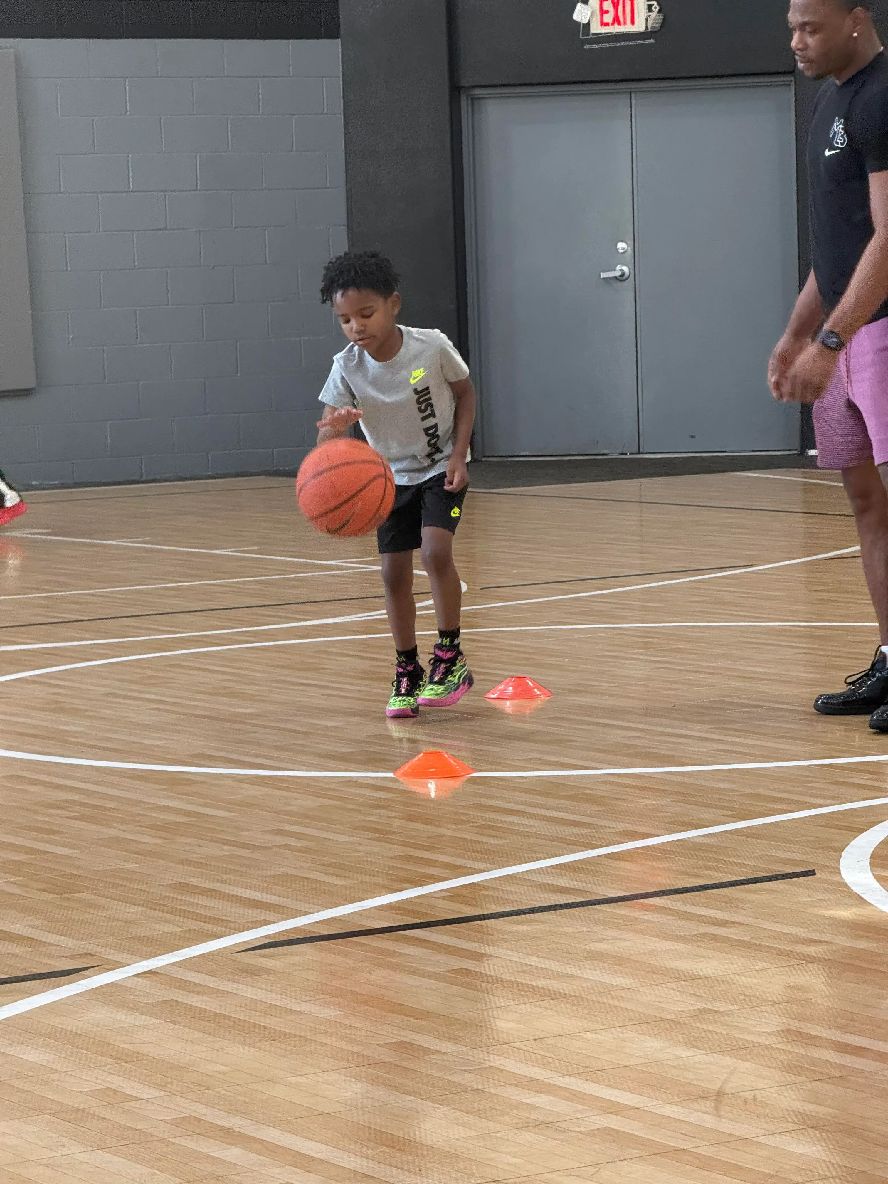 Young basketball player dribbling a basketball in a gym
